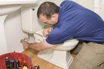Plumber repairing a toilet